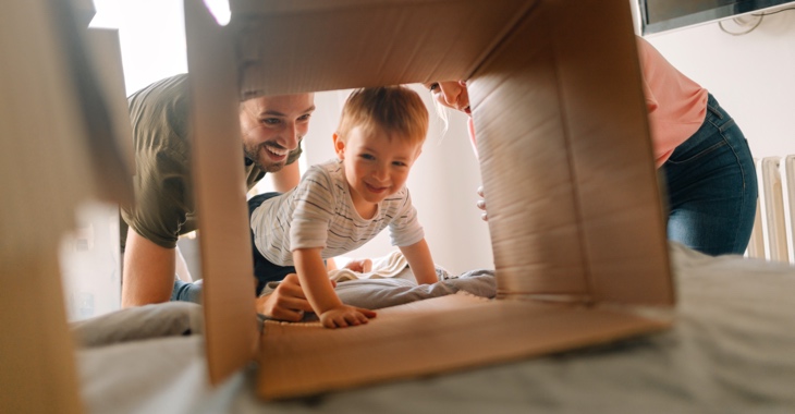 Eltern mit ihrem Sohn, der in eine Pappkiste krabbelt © iStock/AleksandarNakic Eltern mit ihrem Sohn, der in eine Pappkiste krabbelt © iStock/AleksandarNakic