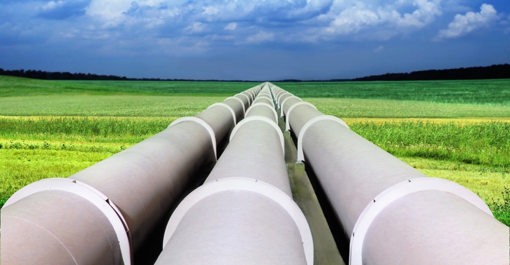 Eine Gaspipeline mit drei riesigen Röhren führt über ein grünes Feld © iStockphoto.com/suaphoto