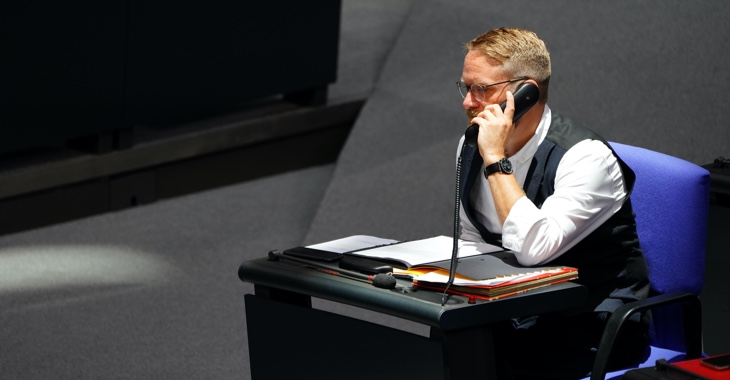 Jan Korte telefoniert an seinem Platz im Plenarsaal des Bundestages