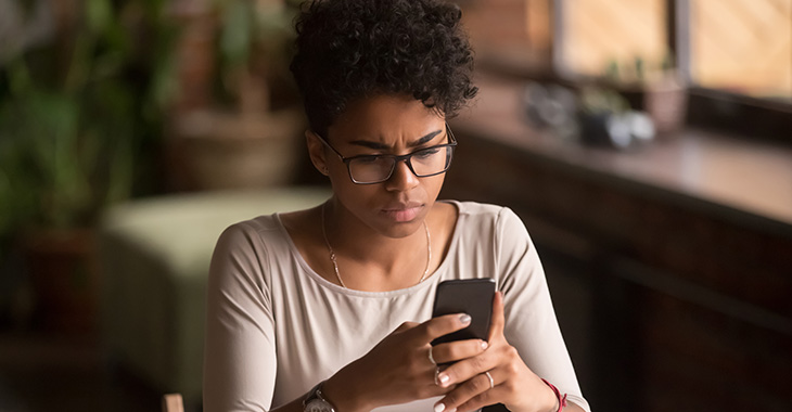 Junge Frau guckt besorgt auf ein Handy iStock/fizkes Junge Frau guckt besorgt auf ein Handy