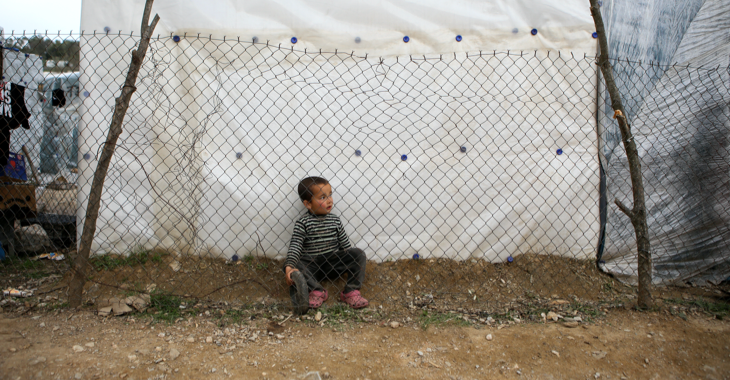 Ein Flüchtlingsjunge sitzt hinter einem Gitterzaun im Lager Moria auf der griechischen Insel Lesbos © REUTERS/Elias Marcou