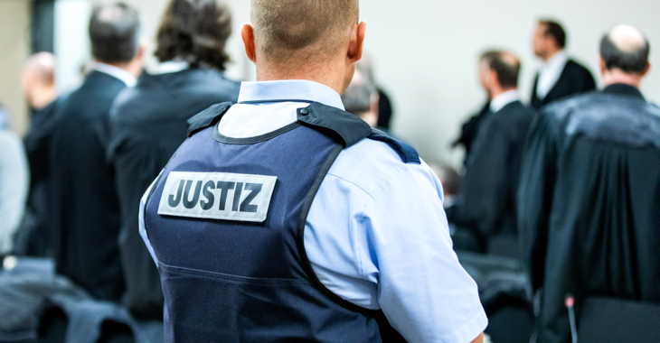 Ein Justizbeamter in einem Gerichtssaal trägt eine Schutzweste mit der Aufschrift Justiz © dpa/Marcel Kusch Ein Justizbeamter in einem Gerichtssaal trägt eine Schutzweste mit der Aufschrift Justiz © dpa/Marcel Kusch