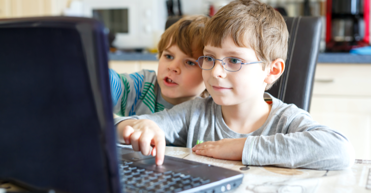 Zwei Kinder sitzen in einer Küche vor einem Computer © iStock/romrodinka