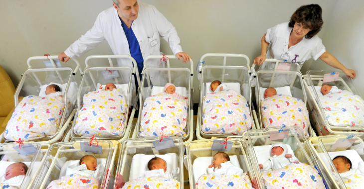 Ein Arzt und eine Krankenschwester hinter zwei Reihen Betten mit Babys in der Neugeborenenstation in einem Krankenhaus in Halle © picture alliance/ZB/Waltraud Grubitzsch