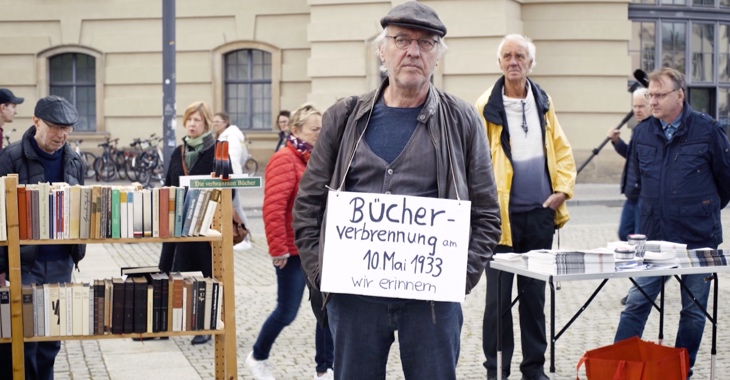 Beim »Lesen gegen das Vergessen« am 10. Mai 2019 auf dem Bebelplatz in Berlin hat ein Teilnehmer ein Schild umhängen mit Aufschrift »Bücherverbrennung am 10. Mai 1933. Wir erinnern.«