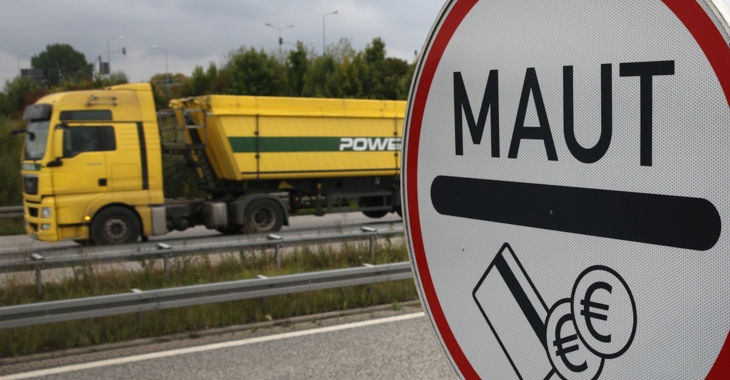 Ein gelber LKW fährt an einem Maut-Schild vorbei © Bernd Wüstneck/dpa