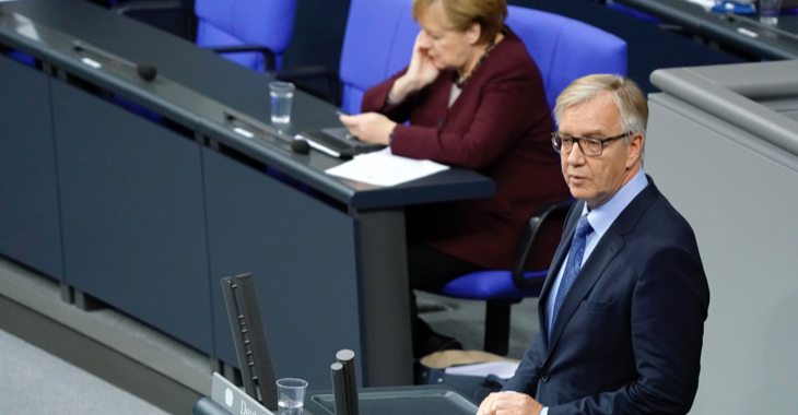 Bundeskanzlerin Merkel schaut währender Antwort von Dietmar Bartsch auf ihre Regierungserklärung auf ihr Handy © picture alliance/Flashpic/Jens Krick