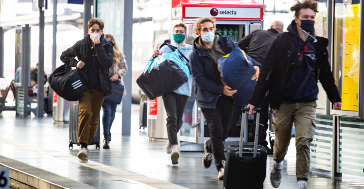 Vier junge Menschen mit Masken und Gepäck auf einem Bahnsteig im Hauptbahnhof Frankfurt am Main © iStock/ollo