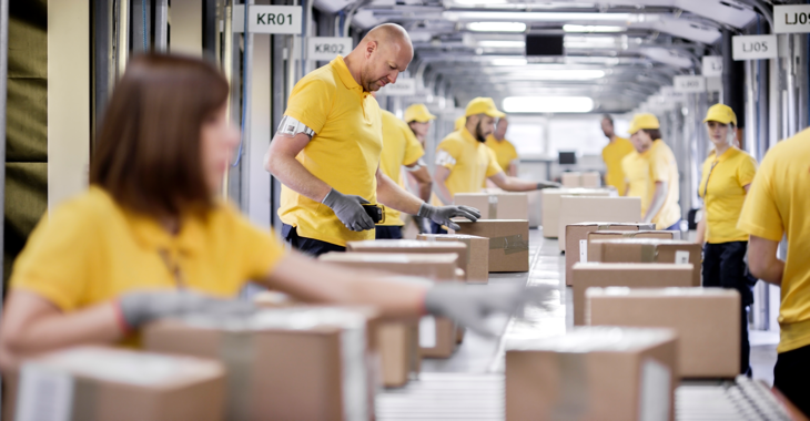 Arbeiter:innen in einem Logistikunternehmen verpacken an einem Fließband Pakete @ iStock/simonkr Arbeiter:innen in einem Logistikunternehmen verpacken an einem Fließband Pakete @ iStock/simonkr