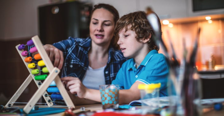 Eine Mutter mit ihrem Sohn rechnen in einem Küche an einem Abakus © iStock/MilosStankovic