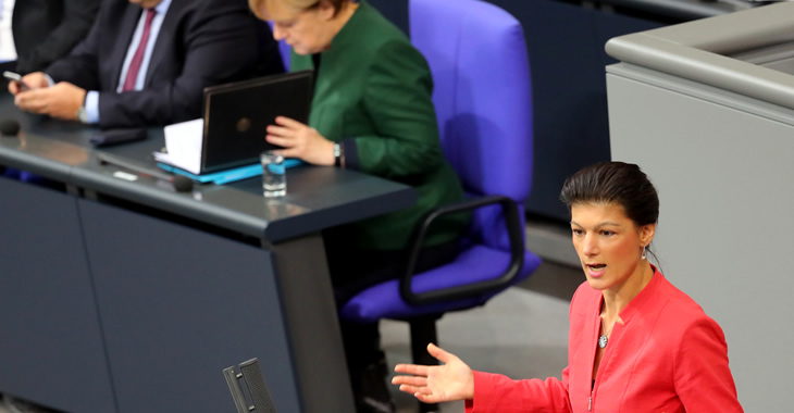 Sahra Wagenknecht am Rednerpult des Bundestages, dahinter Kanzlerin Merkel auf der Reigerungsbank © dpa