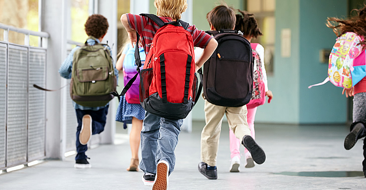 Schulkinder mit Rucksäcken rennen © iStockphoto.com/monkeybusinessimages