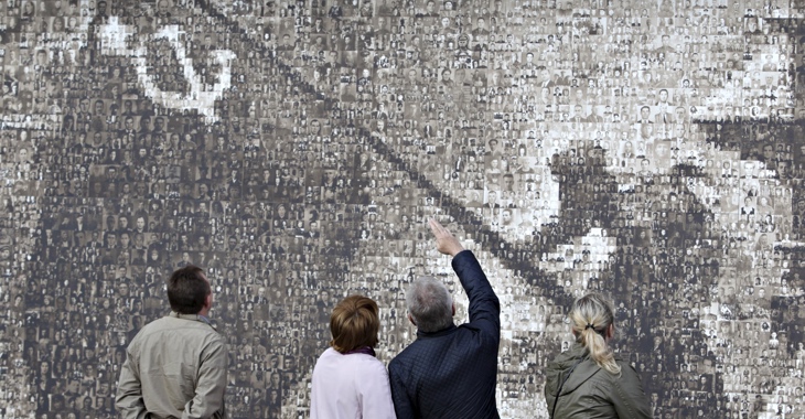 Betrachter vor einer Nachbildung des berühmten Motivs der Sowjetfahne über dem Reichstag, die aus 4.222 Porträtfotos von Einwohnern der russischen Stadt Stawropol, die im Zweiten Weltkrieg ihr Mutterland verteidigt haben, zusammengesetzt ist © REUTERS Betrachter vor einer Nachbildung des berühmten Motivs der Sowjetfahne über dem Reichstag, die aus 4.222 Porträtfotos von Einwohnern der russischen Stadt Stawropol, die im Zweiten Weltkrieg ihr Mutterland verteidigt haben, zusammengesetzt ist © REUTERS/Eduard Korniyenko