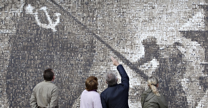 Betrachter vor einer Nachbildung des berühmten Motivs der Sowjetfahne über dem Reichstag, die aus 4.222 Porträtfotos von Einwohnern der russischen Stadt Stawropol, die im Zweiten Weltkrieg ihr Mutterland verteidigt haben, zusammengesetzt ist © REUTERS/Eduard Korniyenko