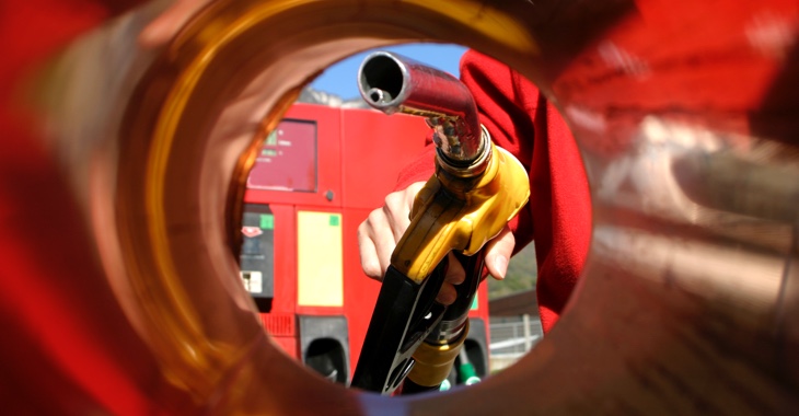 Zapfpistole in einer Hand aus dem Inneres eines Tanks fotografiert © iStock/Brasil2
