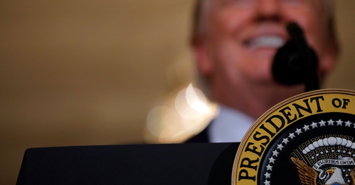 Donald Trump verschommen hinter dem Siegel des US-Präsidenten © Reuters
