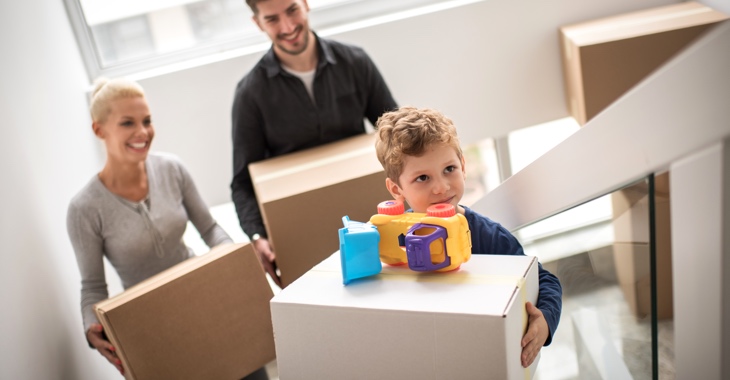 Junge Familie beim Umzug in eine neue Wohnung - Eltern mit ihrem Sohn mit Kisten auf einer Treppe © iStock/Predrag Vuckovic