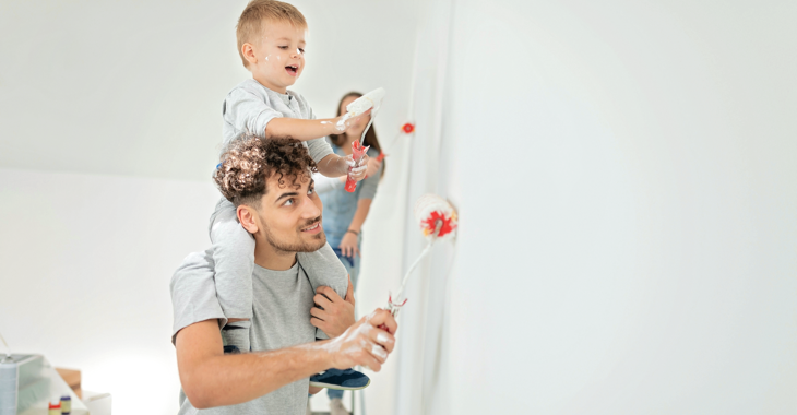 Eine Junge Familie beim Malern ihrer Wohnung, der Sohn mit Farbrolle auf den Schultern des Vaters © iStock/aywan88 Eine Junge Familie beim Malern ihrer Wohnung, der Sohn mit Farbrolle auf den Schultern des Vaters © iStock/aywan88