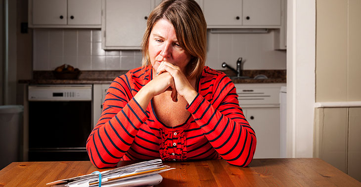 Rechnungen ohne Ende: Besorgte Frau an einem Küchentisch ©istockphoto.com/Fertnig Rechnungen ohne Ende: Besorgte Frau an einem Küchentisch