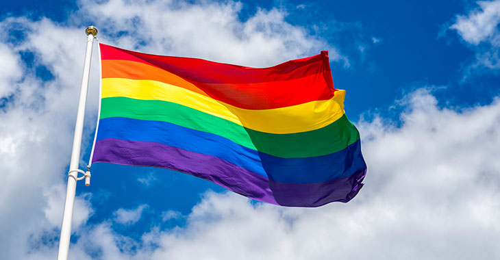 Regenbogenfahne vor blauem Himmel © istockphoto.com / Martin Wahlborg Regenbogenfahne vor blauem Himmel