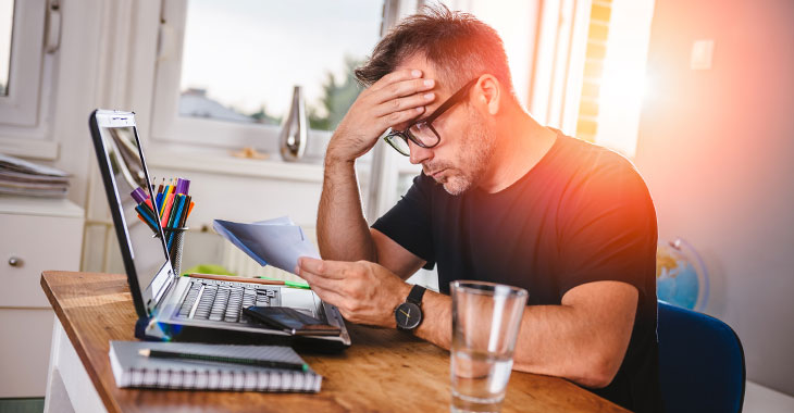 Ein Mann am Schreibtisch grübelt © istockphoteo.com / Kerkez Ein Mann am Schreibtisch grübelt