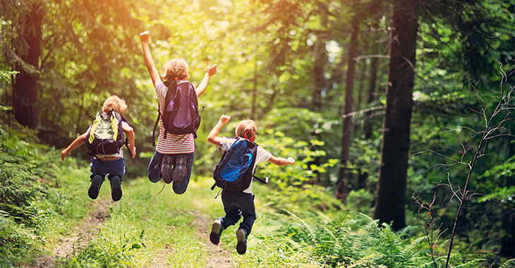 Kinder springen auf einem Waldweg fröhlich in die Höhe | Foto: © istock.com/Imgorthand