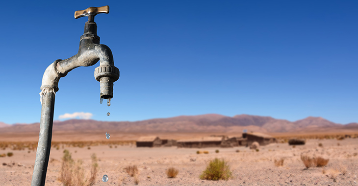 Wasser tropft aus einem Wasserhahn in der Wüste. © istock.com/Angelo D'Amico