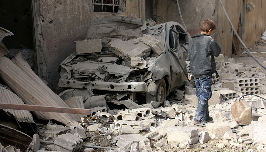 Syrien: Ein Junge geht am 27. November 2017 durch eine von Trümmern bedeckte Straße in einem Vorort von Damaskus. Foto: © picture alliance / abaca Syrien: Ein Junge geht am 27. November 2017 durch eine von Trümmern bedeckte Straße in einem Vorort von Damaskus. Foto: © picture alliance / abaca