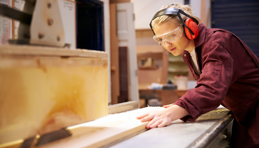 Junge Arbeiterin sägt Holzleisten an einer Kreissäge © iStockphoto.com/monkeybusinessimages