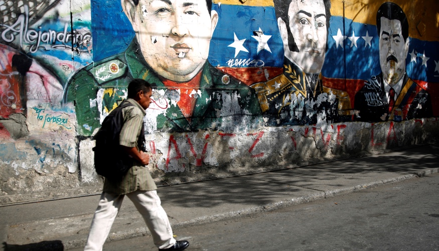 Ein Mann läuft am 30. Januar 2019 in Caracas, der Hauptstadt von Venezuela, an einem Graffiti vorbei, das die Köpfe von Hugo Chavez, Simon Bolivar und Nicolas Maduro zeigt © REUTERS/Carlos Barria Ein Mann läuft am 30. Januar 2019 in Caracas, der Hauptstadt von Venezuela, an einem Graffiti vorbei, das die Köpfe von Hugo Chavez, Simon Bolivar und Nicolas Maduro zeigt © REUTERS/Carlos Barria