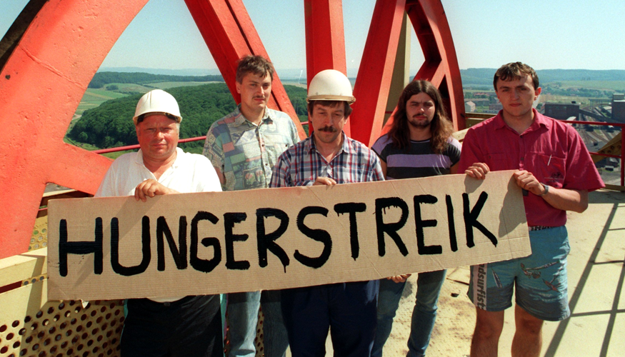 Bergleute halten am 2. Juli 1993 ein Schild mit der Aufschrift Hungerstreik, mit dem sie gegen die von der damaligen Treuhand geplante Schließung der Kaligrube Bischofferode protestieren © dpa/Ralf Hirschberger