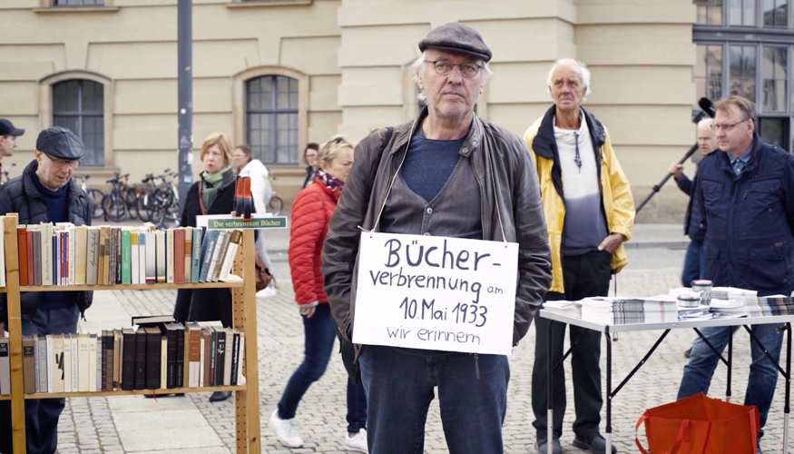 Beim »Lesen gegen das Vergessen« am 10. Mai 2019 auf dem Bebelplatz in Berlin hat ein Teilnehmer ein Schild umhängen mit Aufschrift »Bücherverbrennung am 10. Mai 1933. Wir erinnern.«